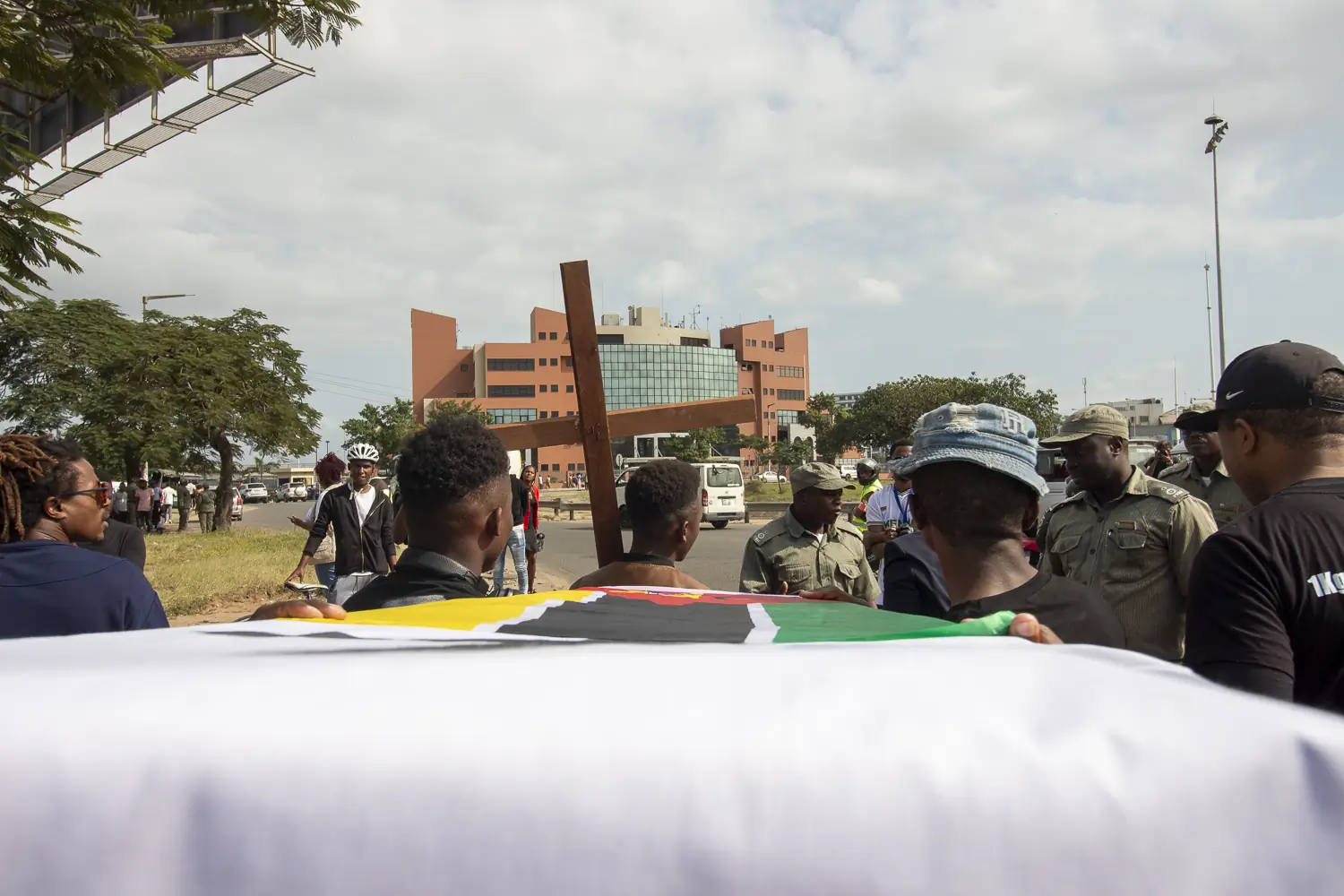 O caixão com o INCM como destino em frente, com obstáculo de alguns agentes da Polícia da República de Moçambique. Após algum mal-entendido sobre o trajecto, o caixão prosseguiu.